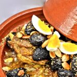 Braised goat shoulder with preserved lemon, green olives, and almonds served in a tagine
