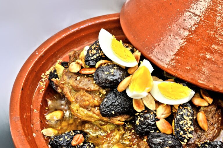 Braised goat shoulder with preserved lemon, green olives, and almonds served in a tagine