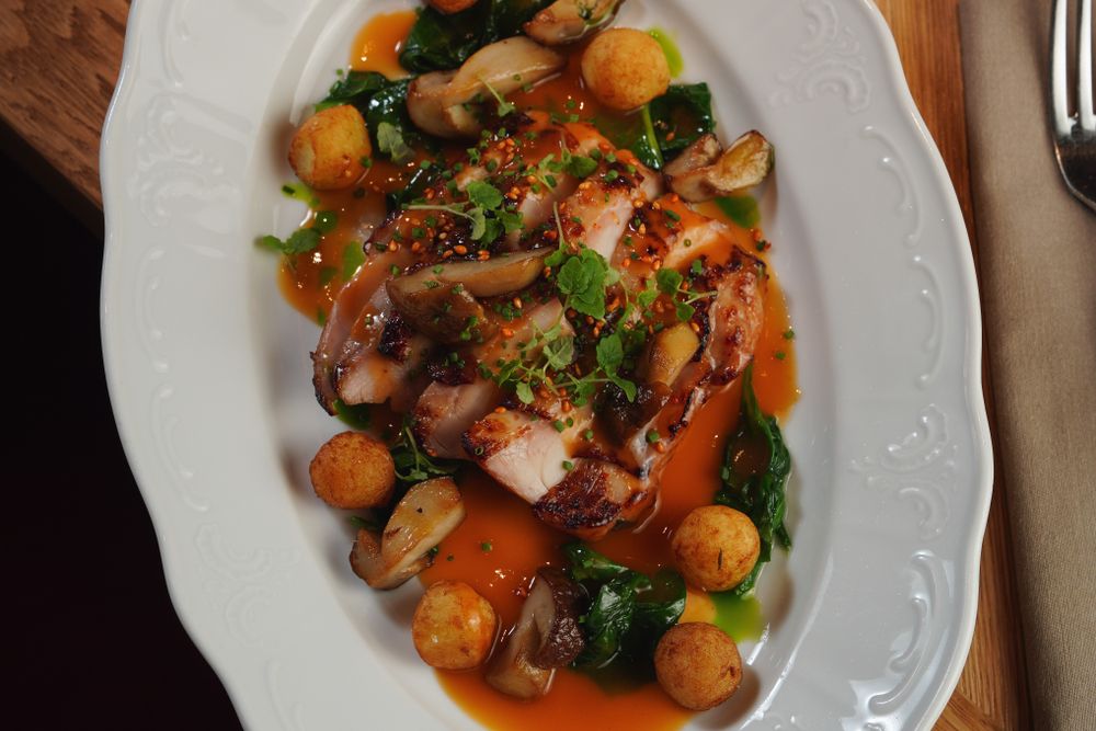 Plated Chicken Marsala with wild mushrooms and Marsala sauce spooned over the top