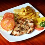 Juicy grilled chicken breast with grill marks served with fresh sides