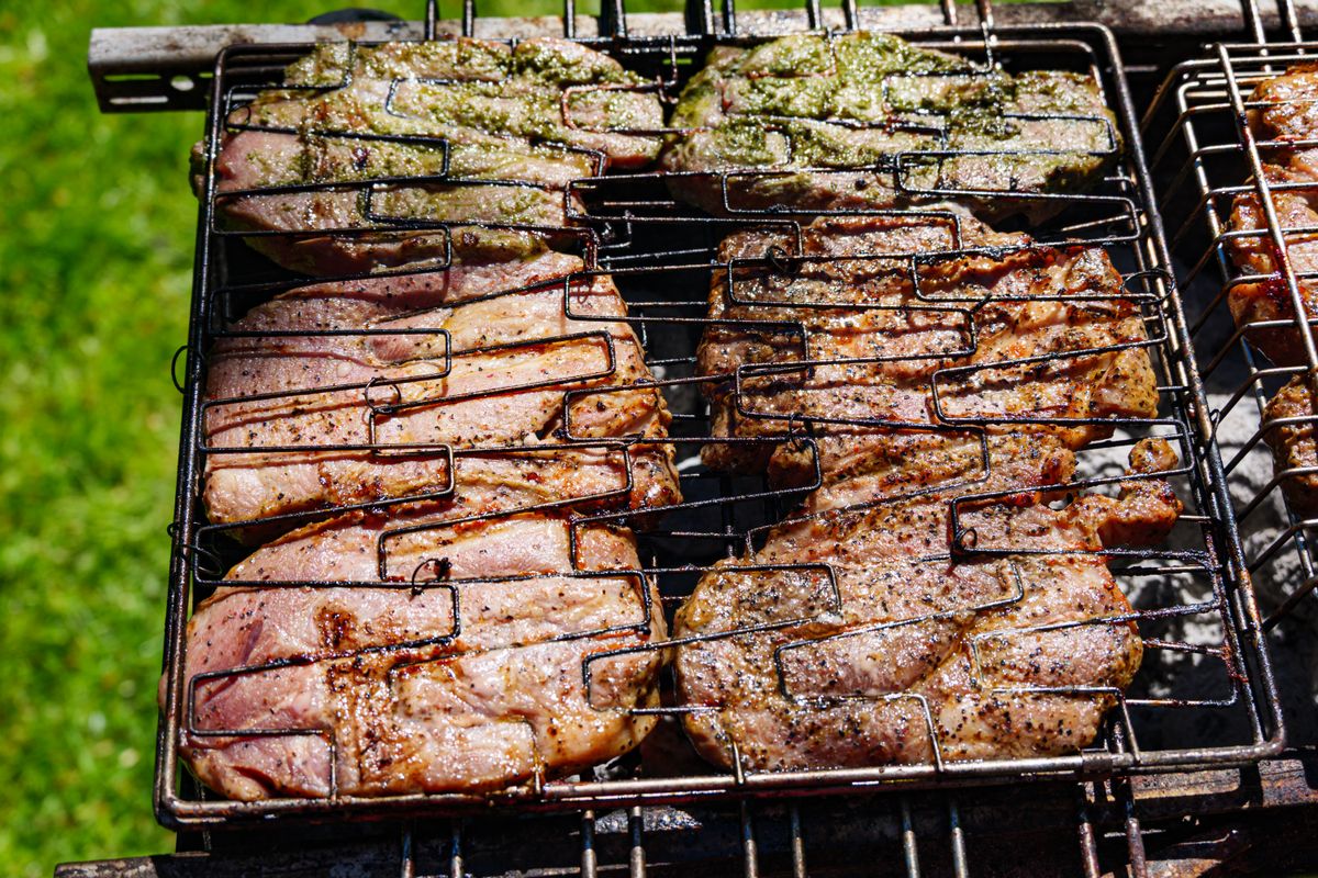 Grilled pork resting on a wooden board after coming off the barbecue