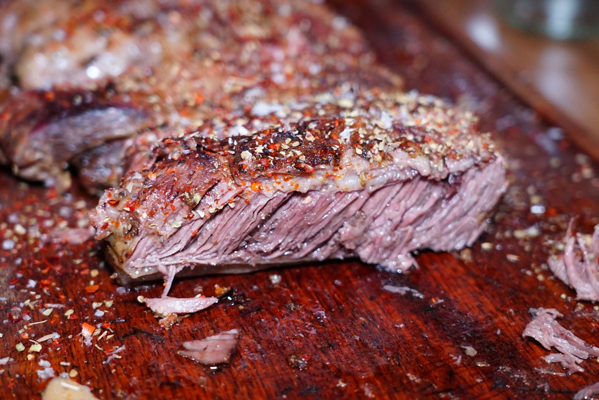 Seasoned sliced beef on a wooden board