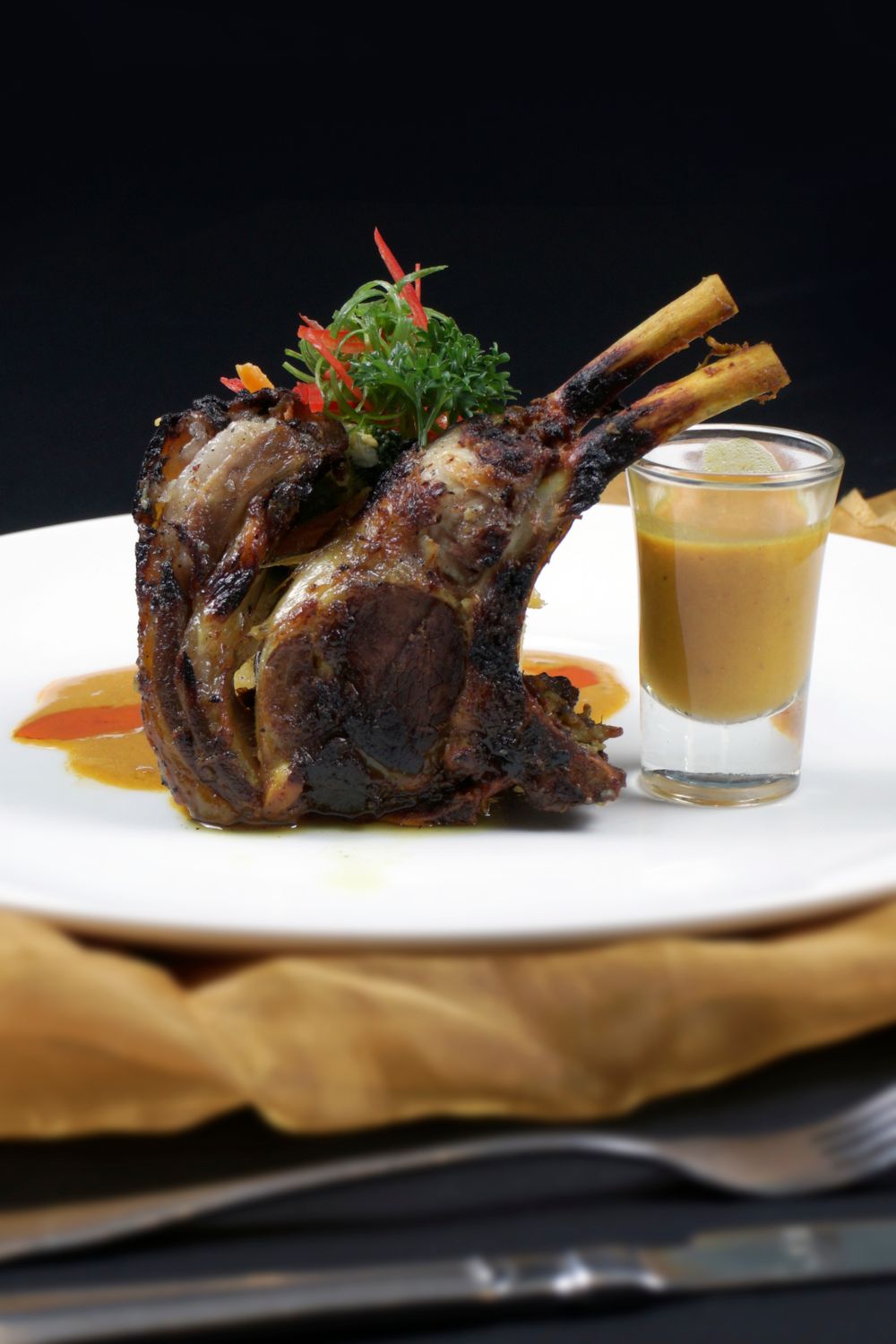 Sliced slow-roasted goat leg served with pan sauce and garnish