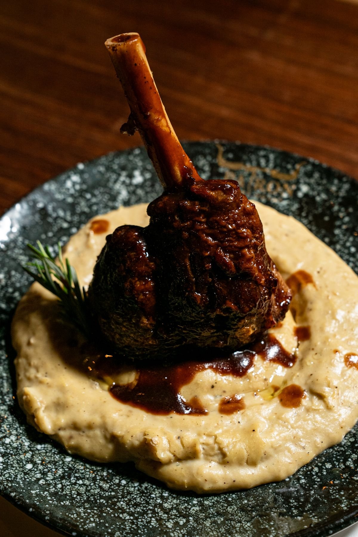 Braised lamb shank in glossy sauce over creamy mashed potatoes