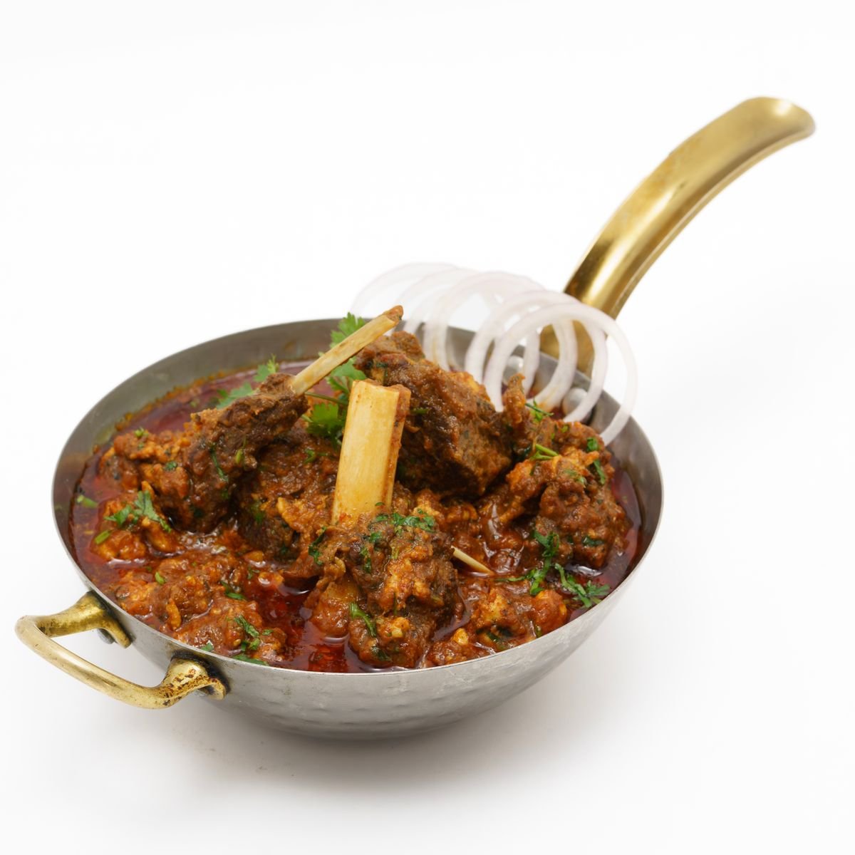 Curry goat simmering in a pot with Scotch bonnet and thyme