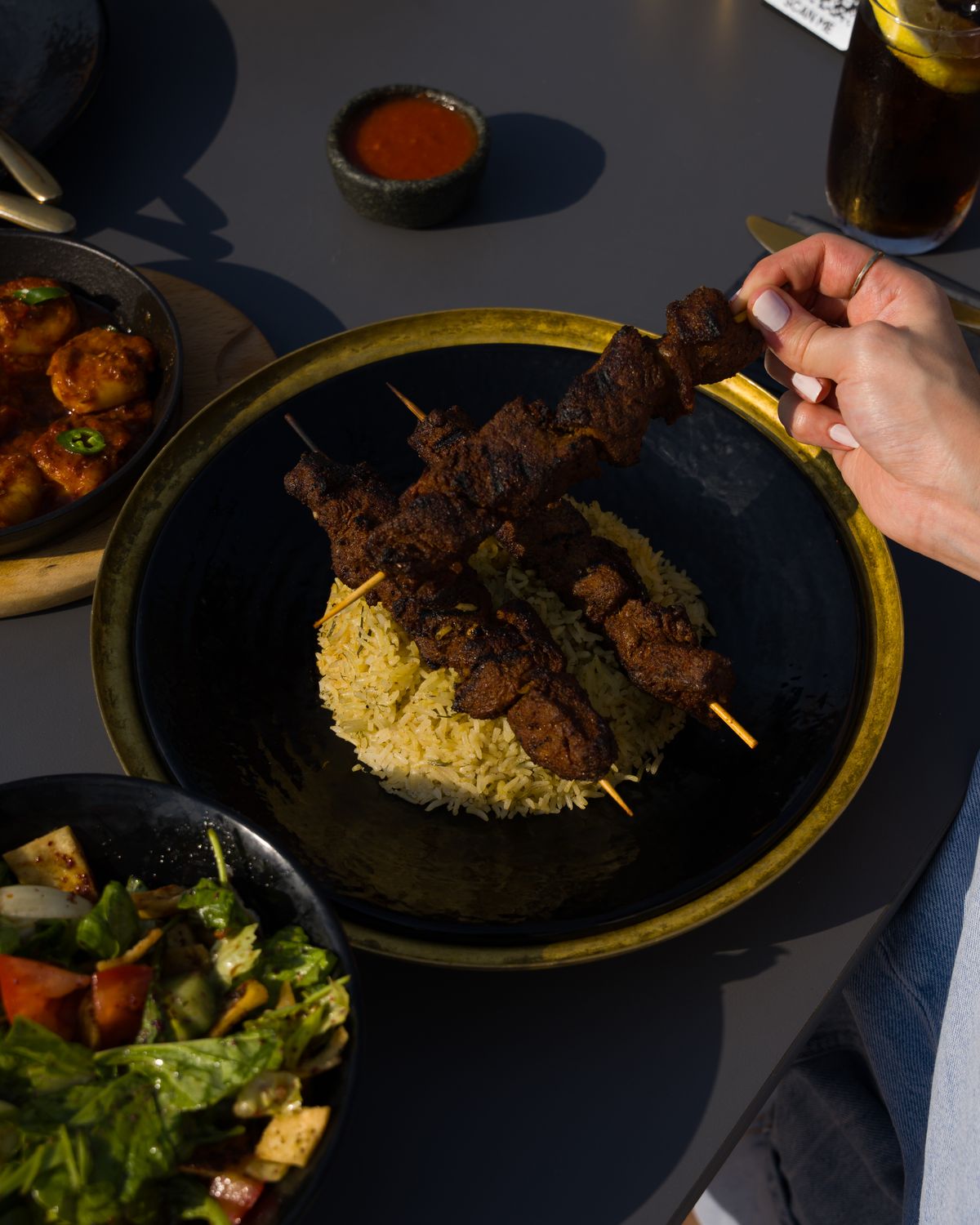 Grilled hanger steak skewers served with rice and salad