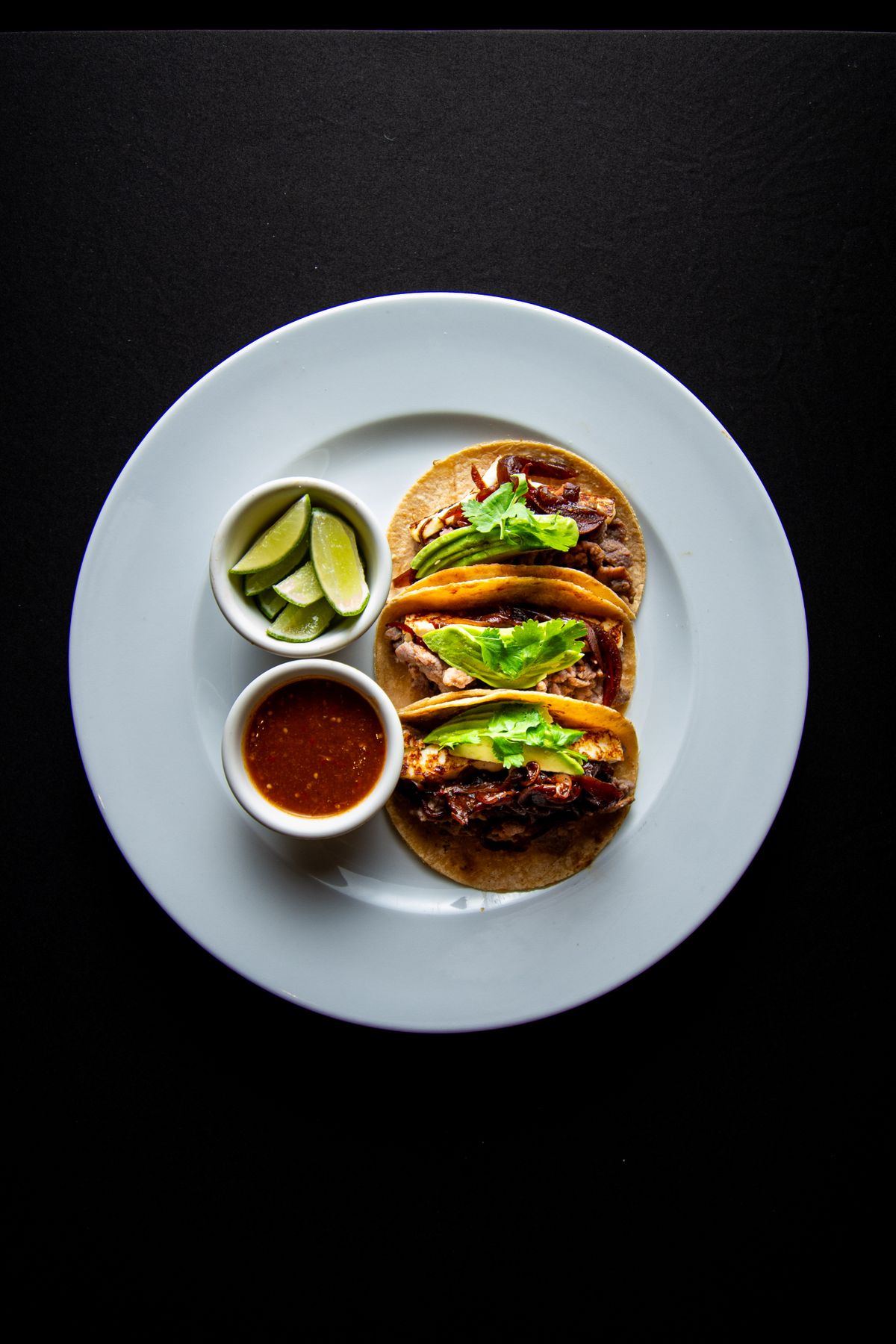 Hanger steak tacos on corn tortillas with lime and salsa