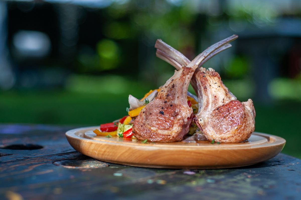 Herb crusted rack of lamb sliced into chops with vegetables