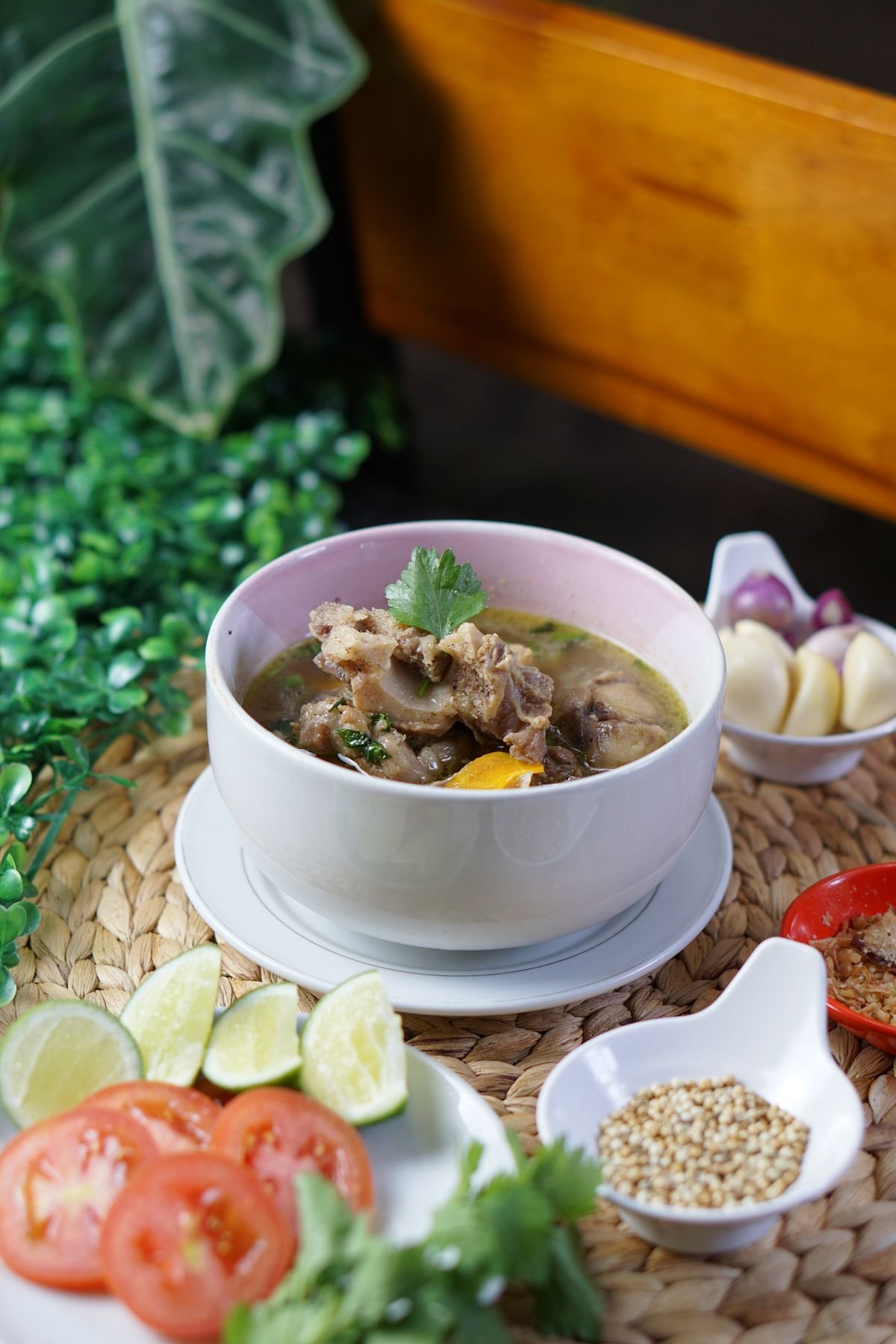 Oxtail segments braising in a pot with vegetables and herbs