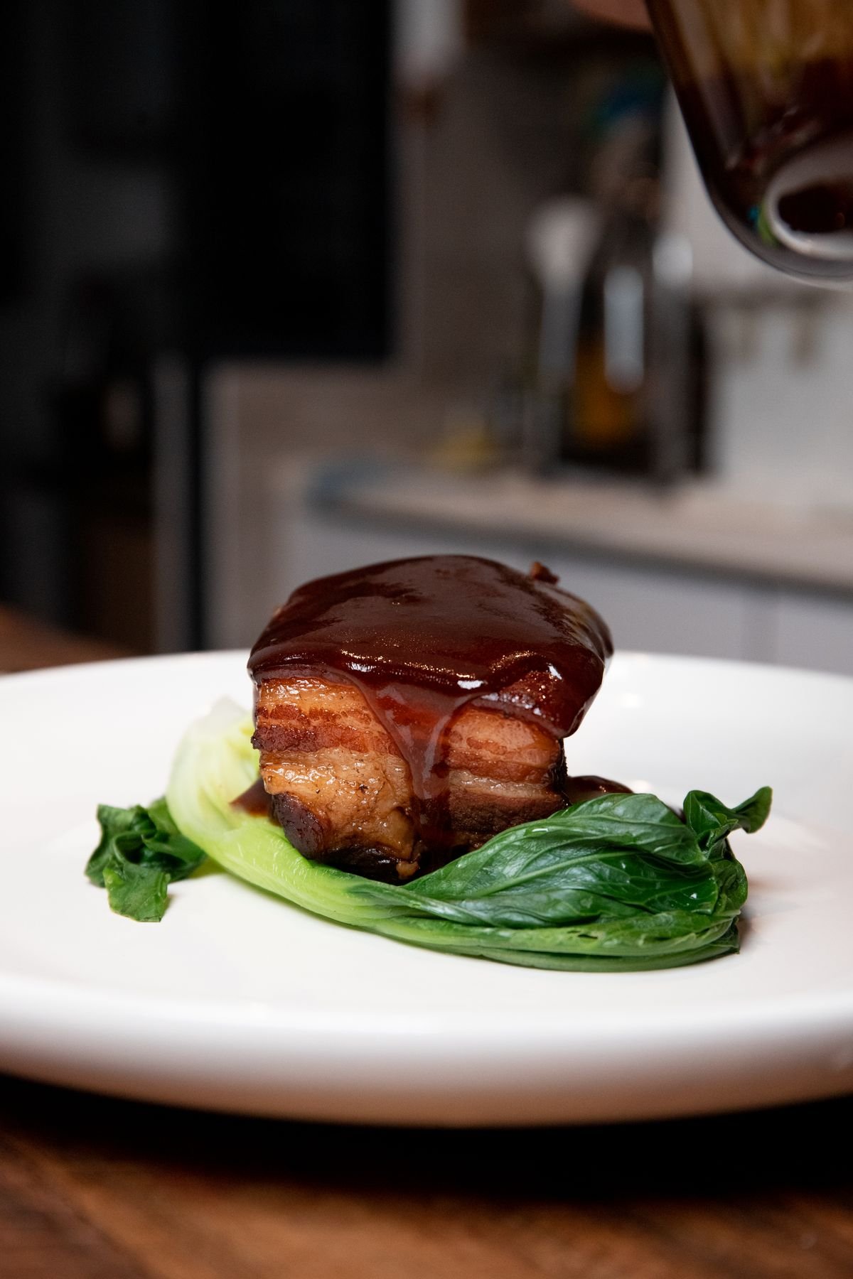 Raw pork belly with its skin scored in a crosshatch