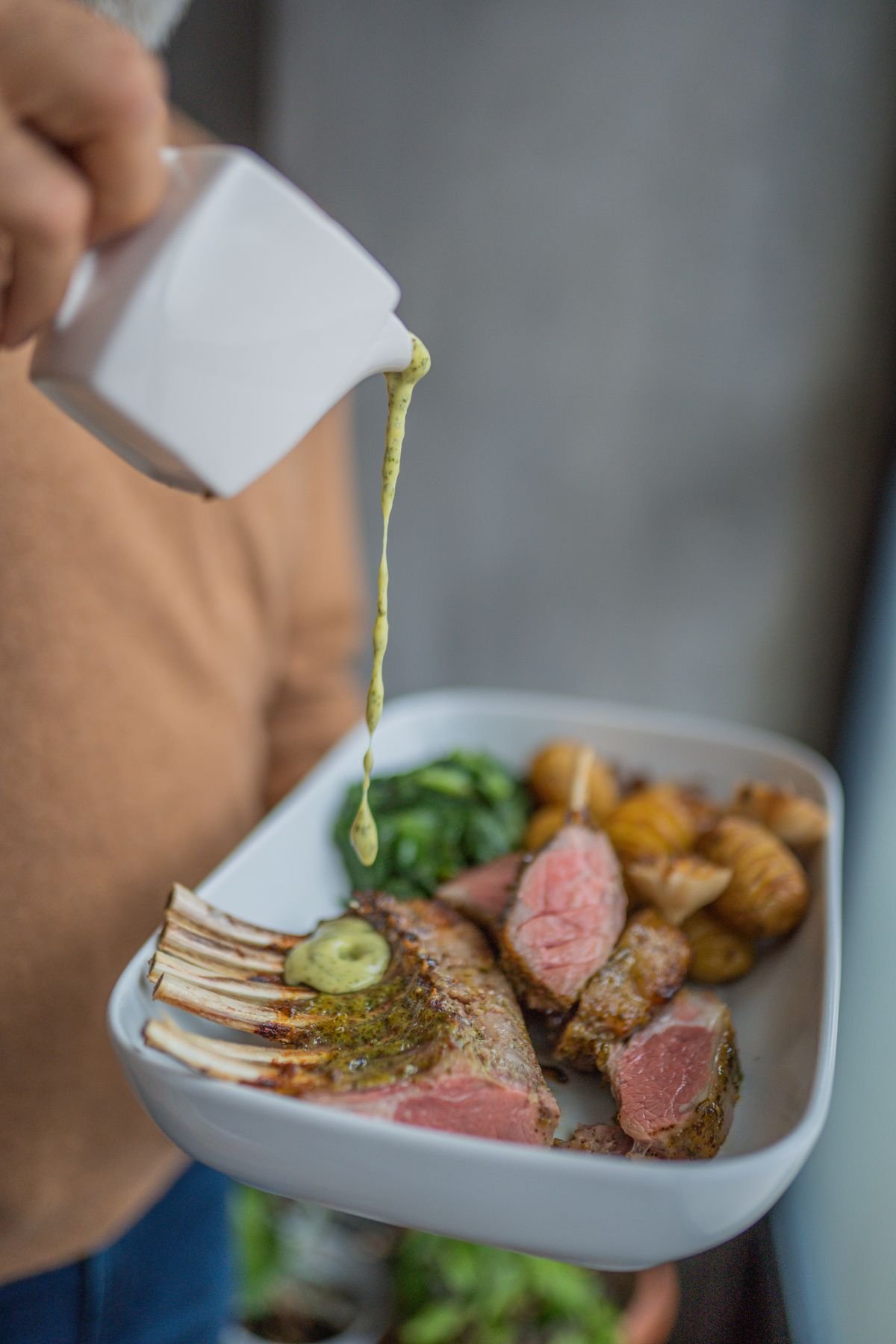 A frenched rack of lamb seasoned before roasting