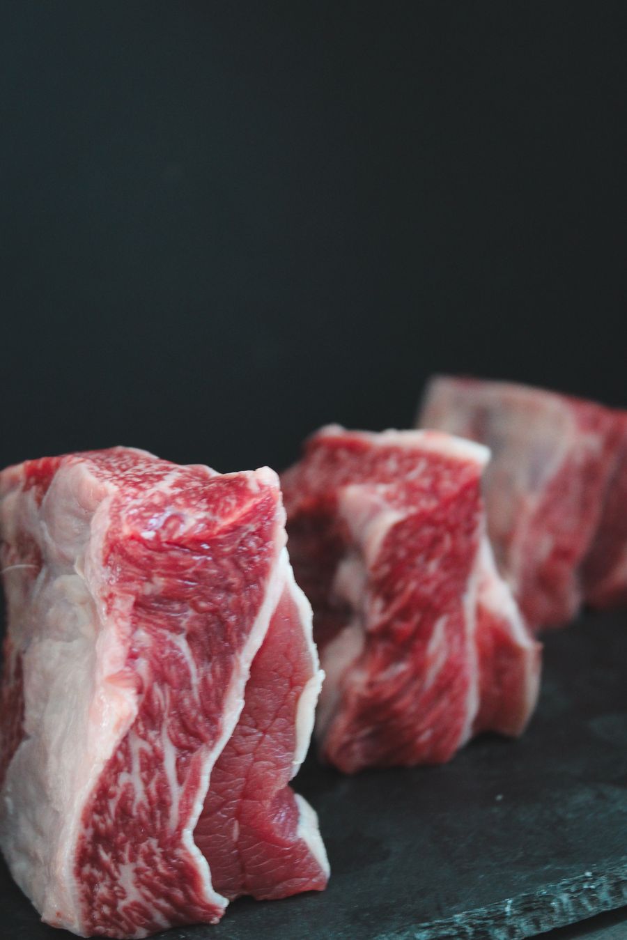 Raw bone-in beef short ribs seasoned with salt and pepper before smoking
