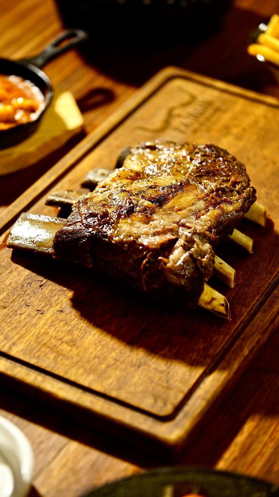 Sliced smoked beef short ribs with gochujang glaze on a wooden board