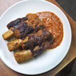 Smoked beef short ribs coated in gochujang glaze on a serving board