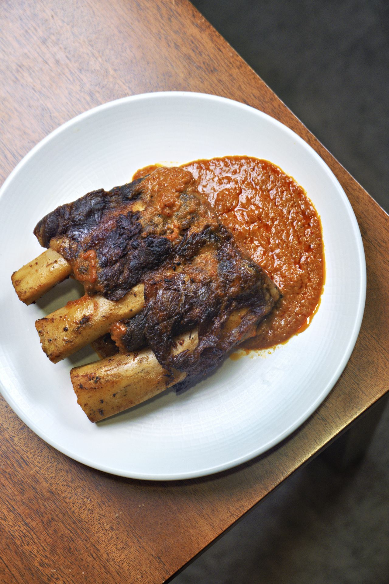 Smoked beef short ribs coated in gochujang glaze on a serving board