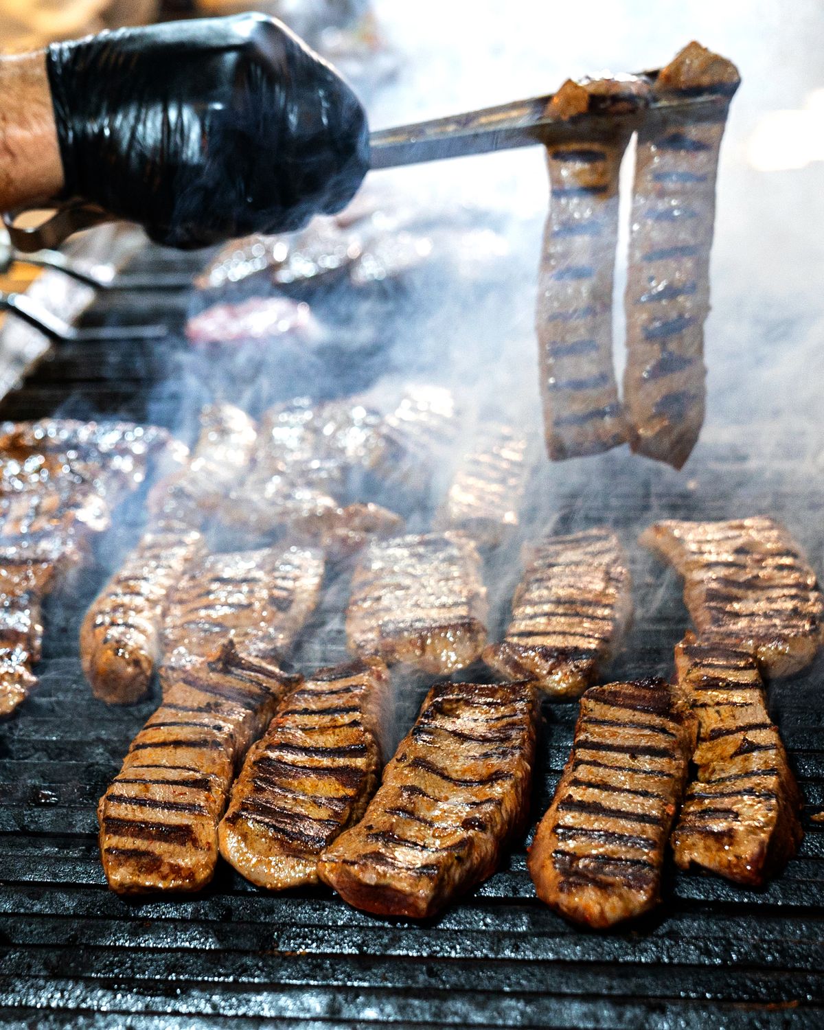 Hanger steak smoking on a grill with smoke rising