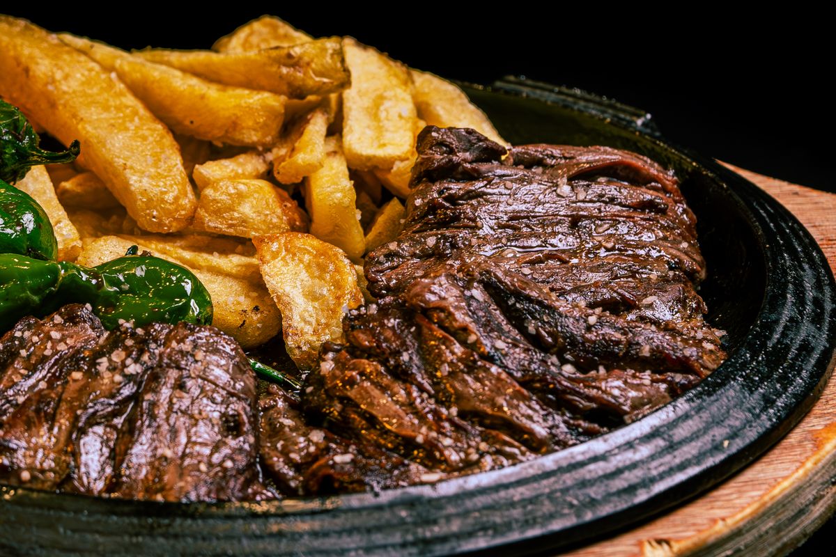 Sliced smoked hanger steak served on a dark plate