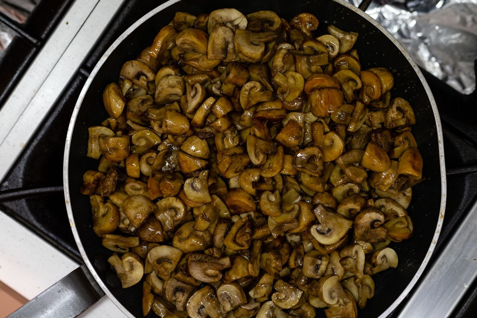 Finely chopped mushrooms cooking down in a pan for a bison meatloaf