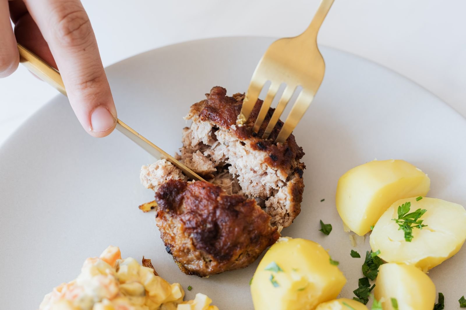 Slicing into a rested meatloaf to show a moist even crumb
