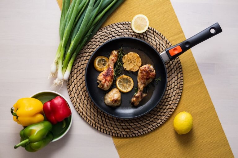 Cast iron chicken thighs with charred lemon slices and capers in a skillet