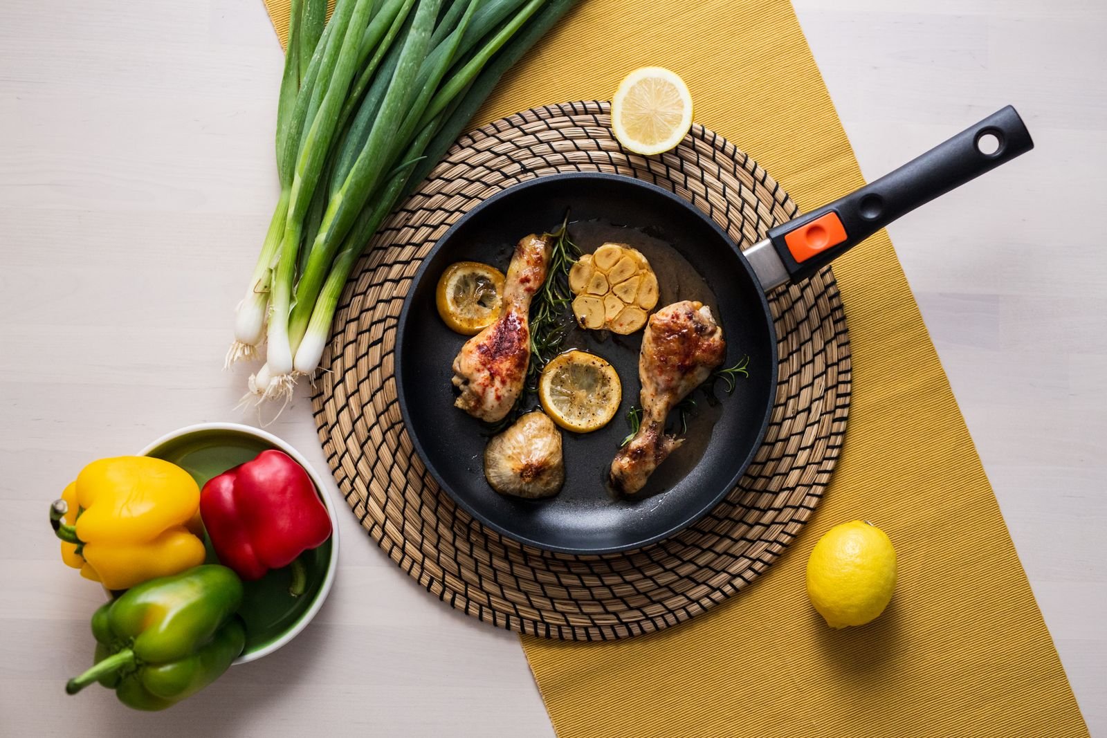 Cast iron chicken thighs with charred lemon slices and capers in a skillet