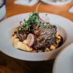 Coffee and cocoa braised beef chuck in a dark glossy sauce over mashed potatoes