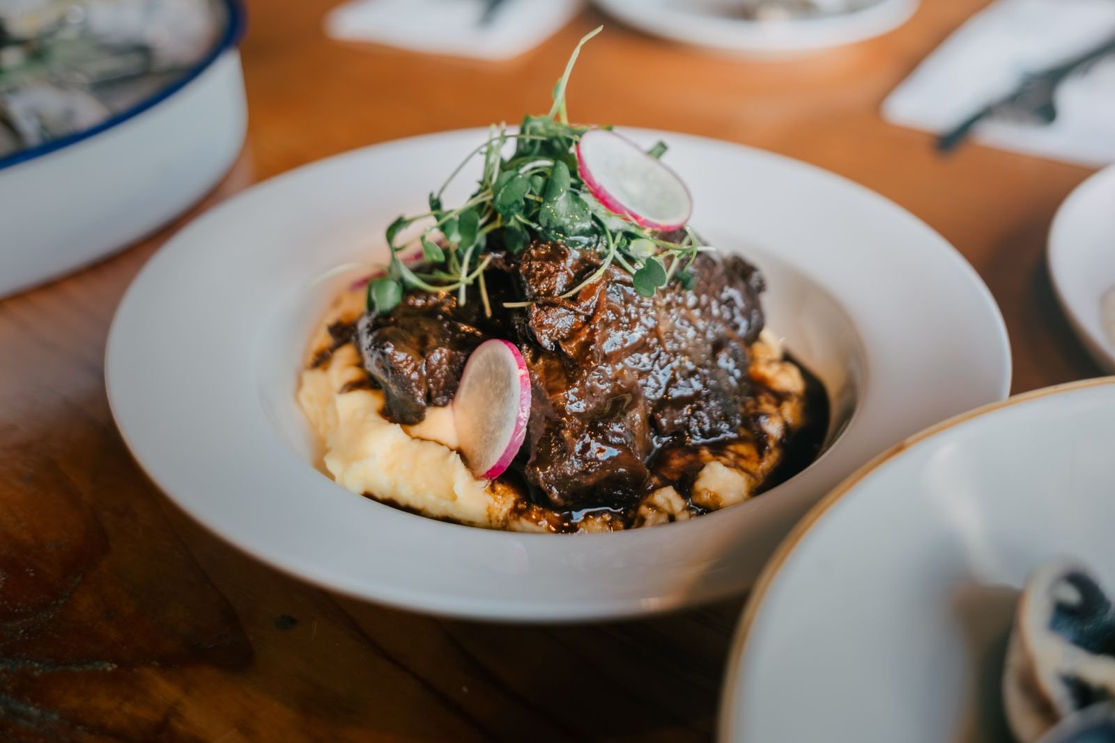 Coffee and cocoa braised beef chuck in a dark glossy sauce over mashed potatoes