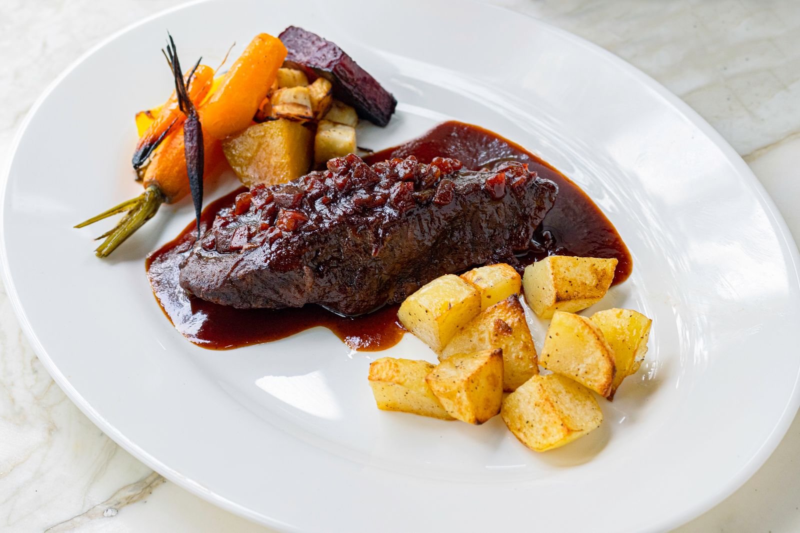 Braised beef in a rich dark sauce served with roasted vegetables