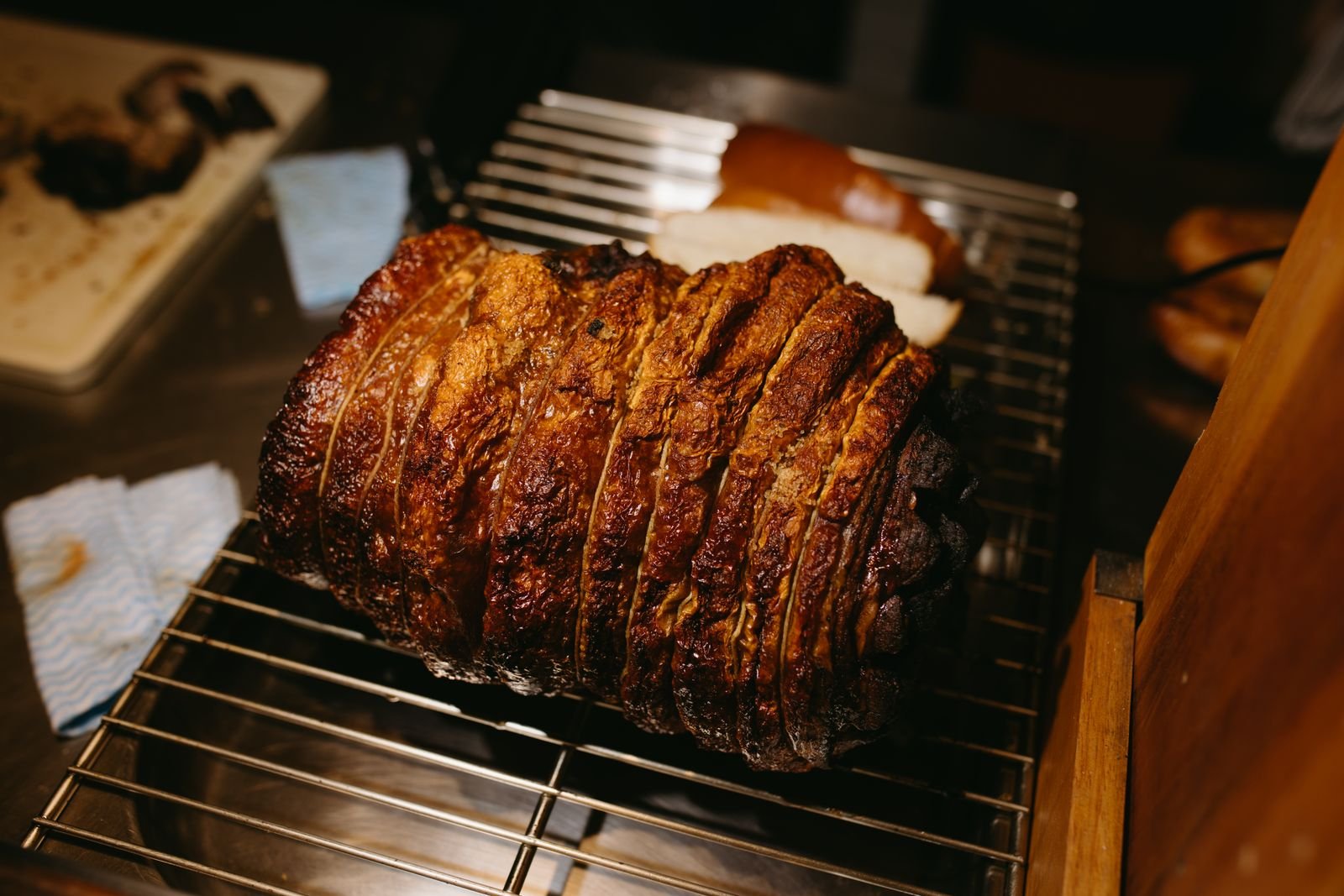 Pork shoulder roasting on a rack until the skin blisters and crisps