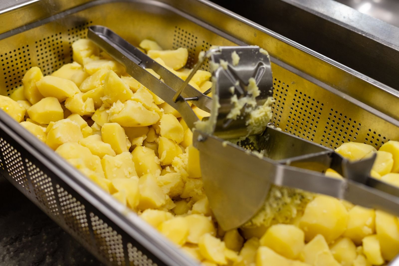 Boiled potatoes pushed through a metal ricer for a smooth shepherds pie topping