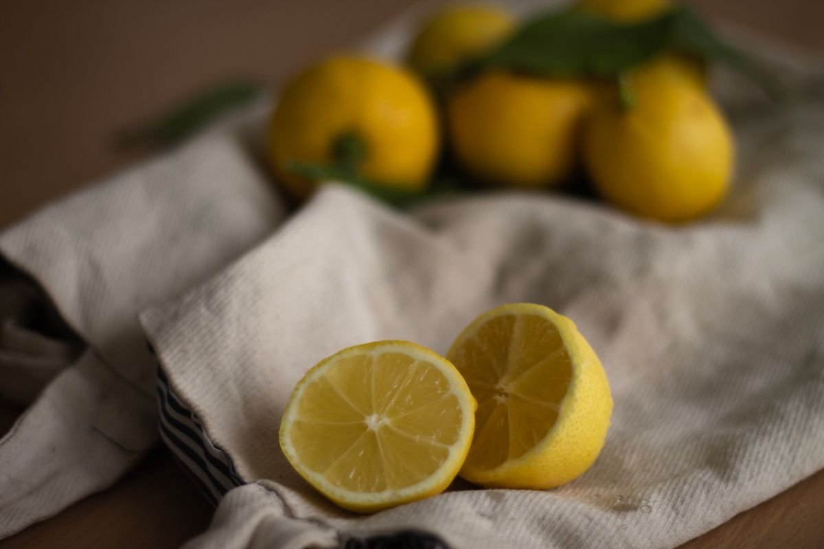 Halved lemons on a linen cloth ready to be charred cut side down in a hot skillet
