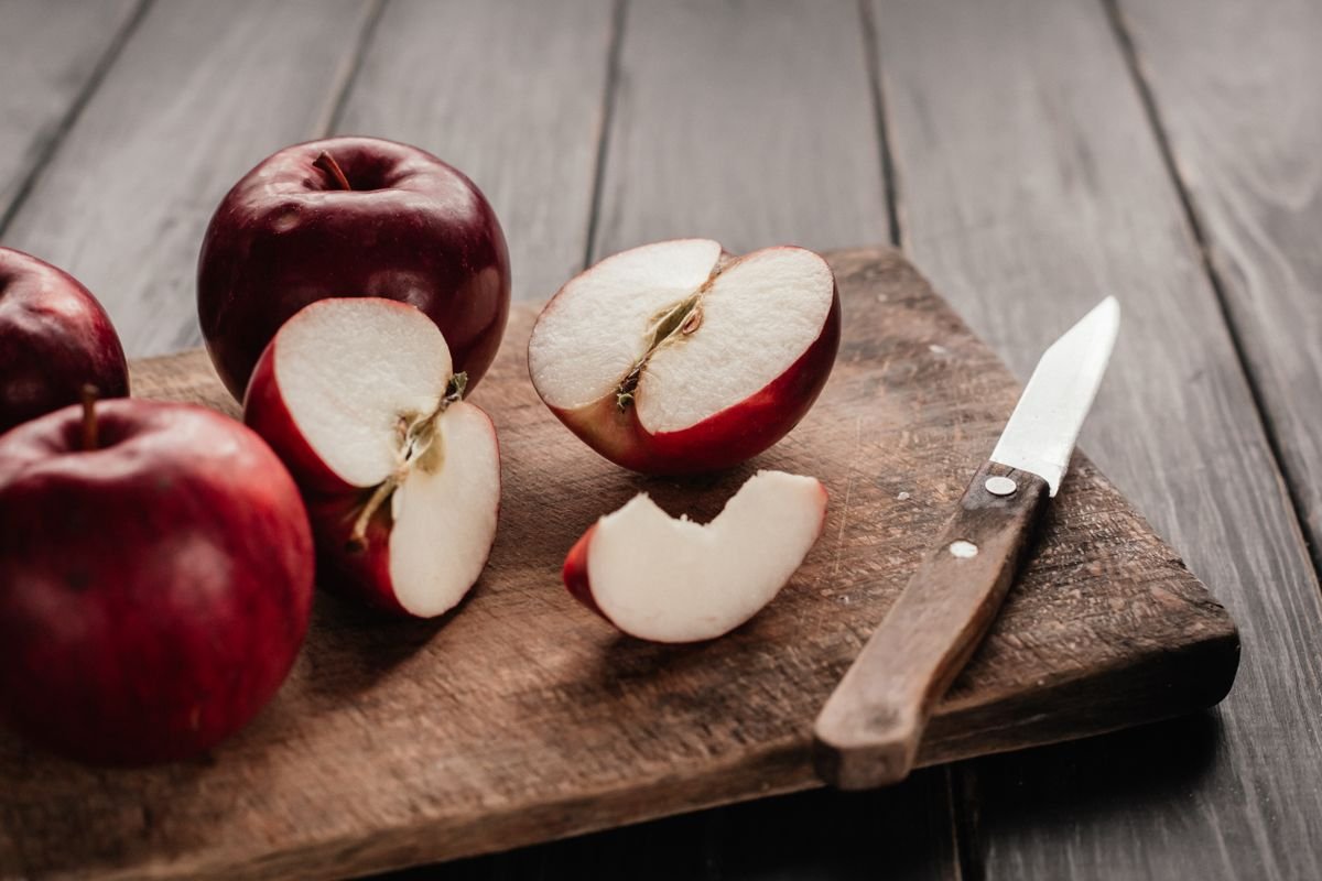 Sliced apples on a wooden board for the cider pan sauce that goes with pork chops