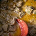 Beef bourguignon simmering in a Dutch oven with a rich red wine sauce