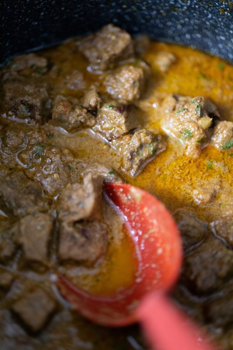 Beef bourguignon simmering in a Dutch oven with a rich red wine sauce