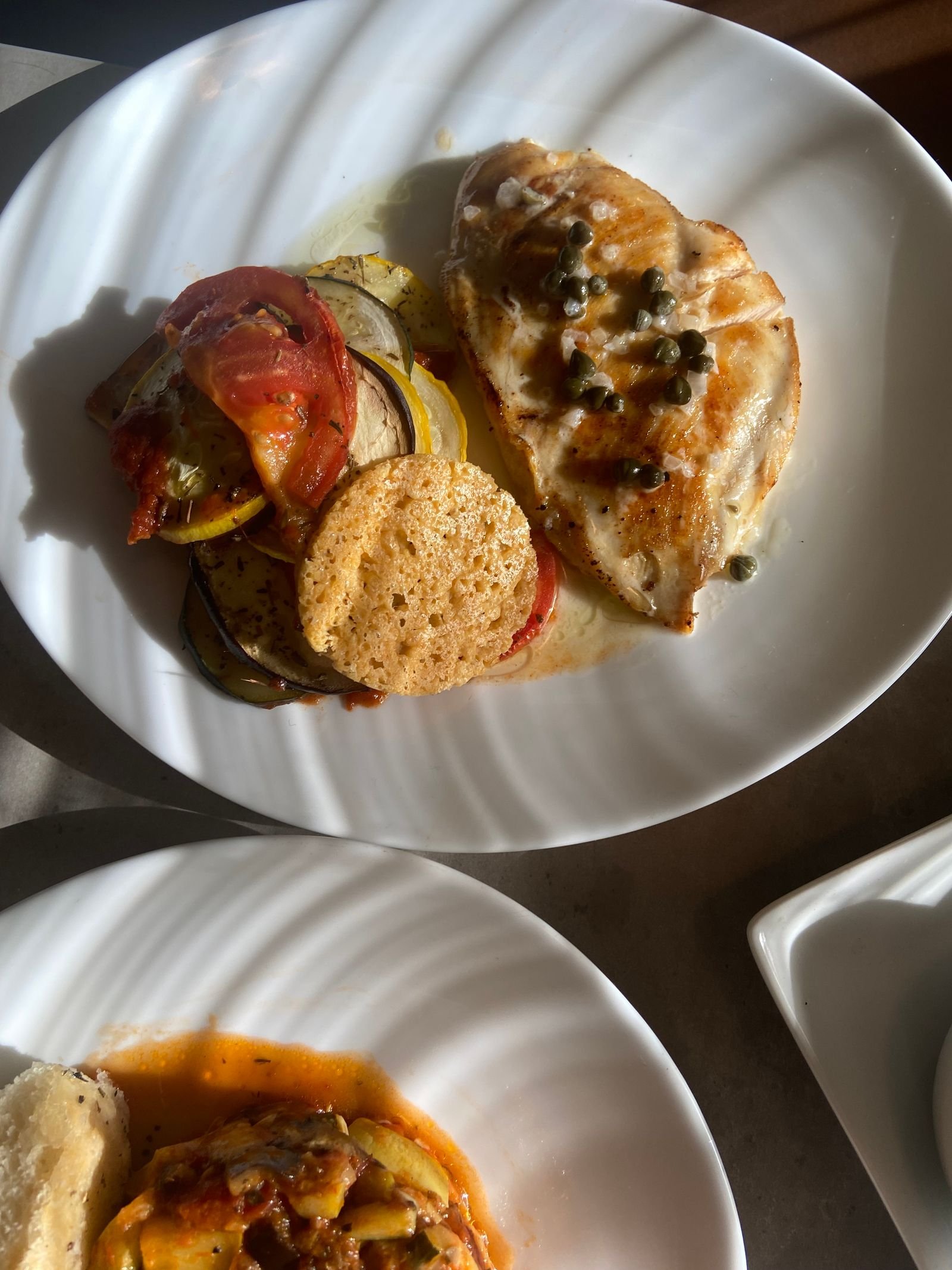 Chicken breast plated with capers and a lemon butter pan sauce