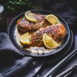 Chicken piccata cutlets in a pan with lemon slices and butter sauce