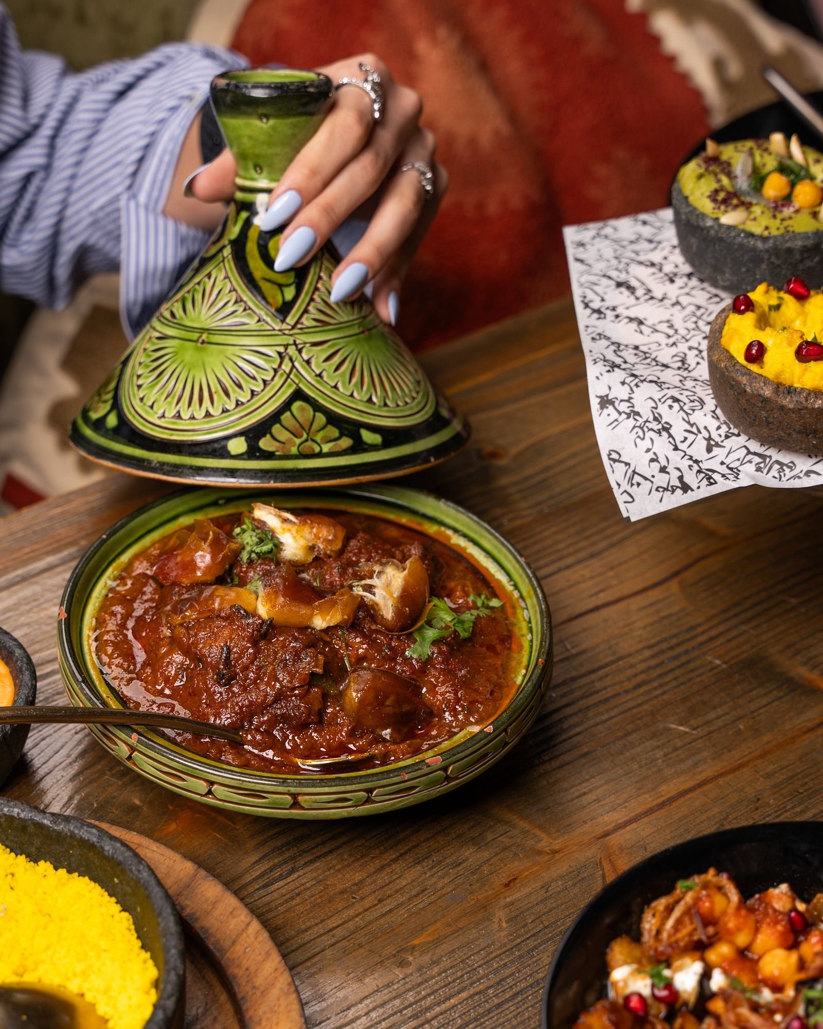 Lamb tagine served with couscous and Moroccan sides