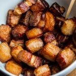 Crisp glazed pork belly burnt end cubes served in a white bowl