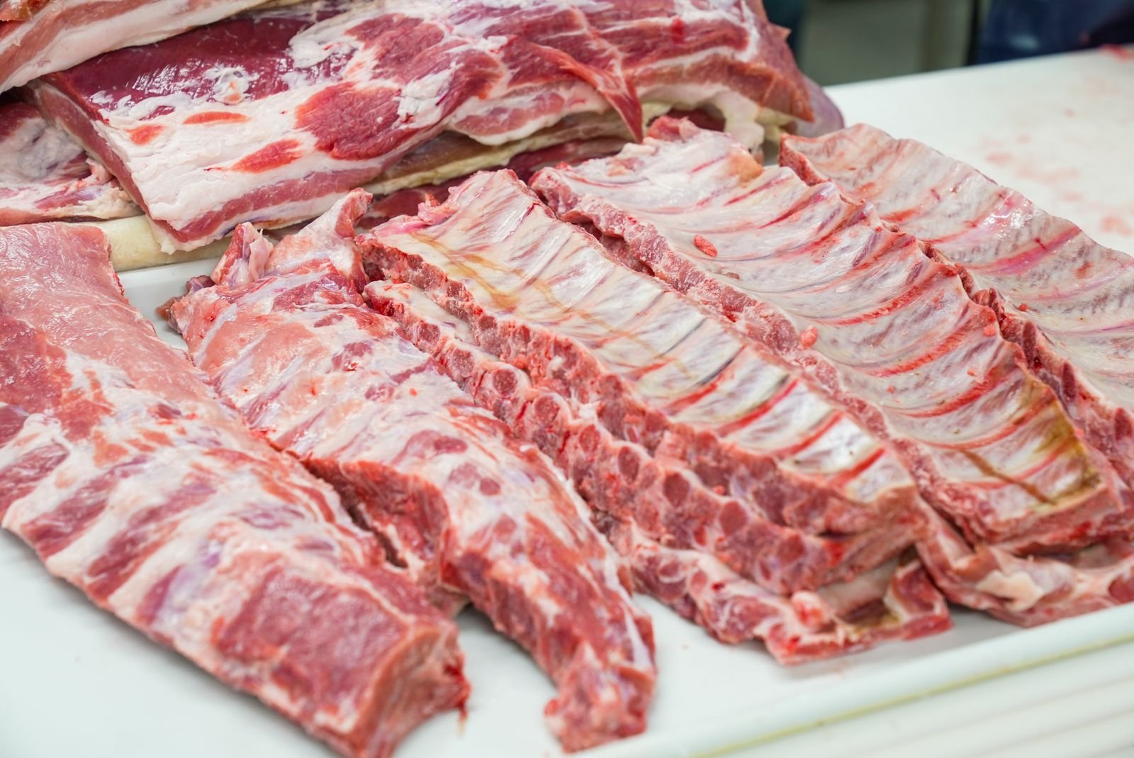 Raw pork rib racks laid out on a cutting board before trimming